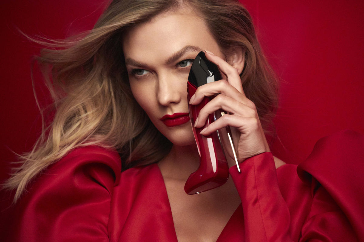 a woman in a red dress talking on a cell phone 